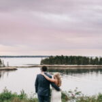 a newly wed couple standing by the water at Grey Havens Inn.