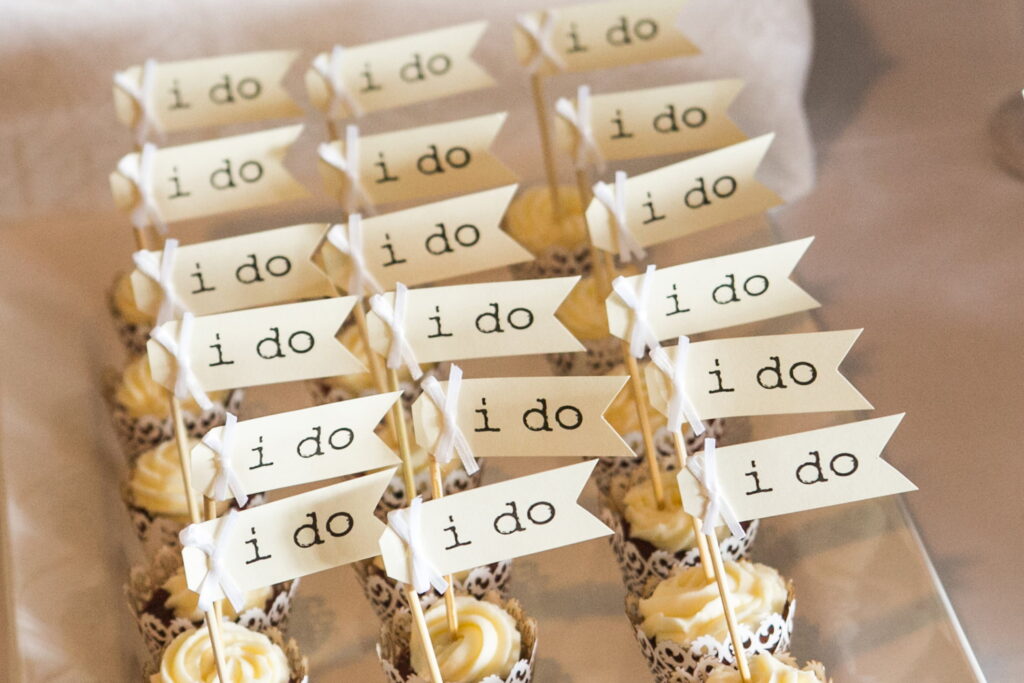 A row of Row of 'I Do' wedding cupcakes.