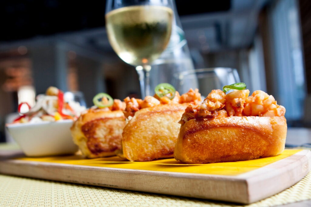 Gourmet mini lobster rolls and a glass of wine at a restaurant near Portland, Maine.
